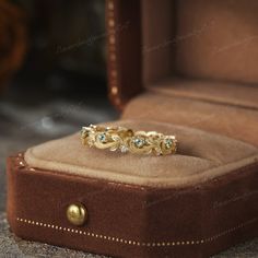 a gold ring with blue topaz sits in a velvet box on the floor next to an open case