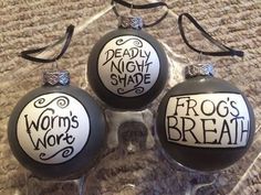 three glass ornaments with words on them sitting on a carpeted floor next to each other