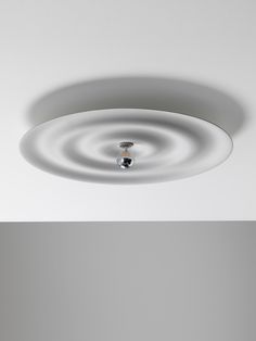 a white ceiling light with a circular design on it's face and bottom half