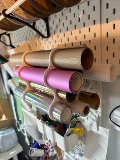 several rolls of colored paper are hanging on the wall next to each other in a craft room