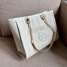 Description CC Deauville Tote Tweed Bag Summer Collection White For Women 15.7in/40 cm Rep 1:1 Measurements: 40 x 22 x 30 cm / 15/7 x 8.6 x 11.8 inches (Length x Width x Height) Chain White Gold-toned hardware Include dust bag. This product is of the best quality. Baby Tote Bag, Tweed Bag, Louis Vuitton Shirt, Vanity Bag, Stylish Handbags, Bag Summer, Luxury Products, Evening Clutch Bag, Chanel Handbags