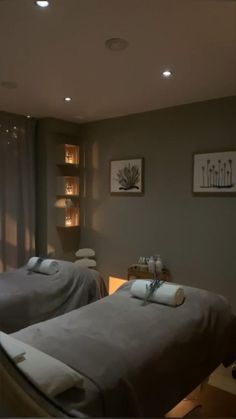 two massage beds with towels on them in a room that is lit up by lights