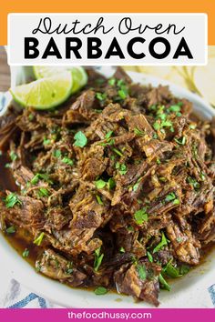 a white plate topped with shredded beef and garnished with cilantro sauce