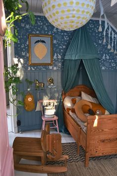 a child's bedroom with a bed, rocking chair and toy horse on the floor