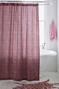 a bathroom with a pink shower curtain next to a white bath tub