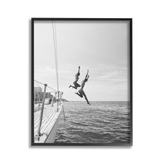 a black and white photo of a person jumping off the side of a boat into the ocean