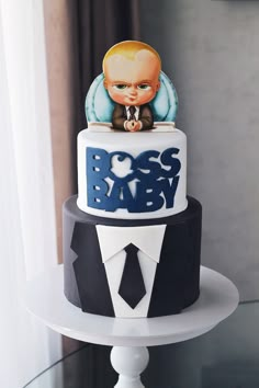 a three tiered cake decorated with an image of a baby in a suit and tie