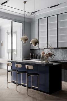 an elegant kitchen with marble counter tops and dark blue cabinets, along with bar stools