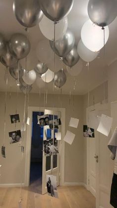 the room is decorated with silver balloons and pictures hanging from the ceiling, along with other decorations