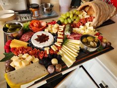 an assortment of cheeses and meats on a platter