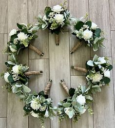 flowers arranged in the shape of a wreath on top of a wooden floor next to wine corks