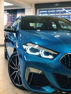 a blue bmw car is parked in a showroom