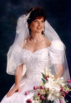 a woman in a wedding dress holding a bouquet