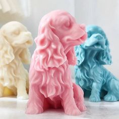 three different colored dog figurines sitting next to each other