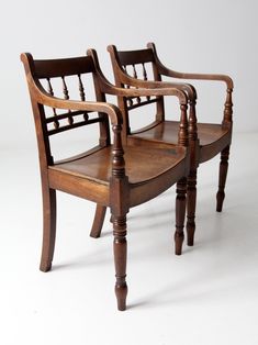 two wooden chairs sitting next to each other