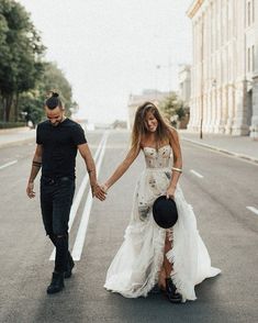 a man and woman walking down the street holding hands