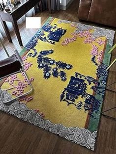 a living room area with a chair and rug on the floor next to a couch