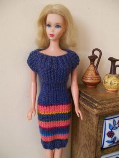 a doll is standing next to a table with vases on it and a wooden cabinet