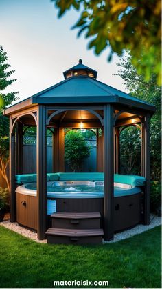 Octagonal hot tub inside a gazebo with lush greenery in the background.