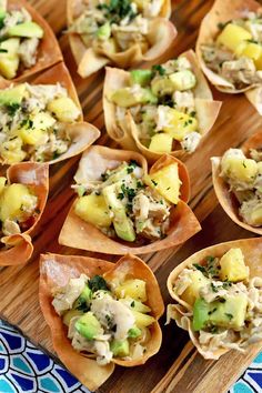 small cups filled with food sitting on top of a wooden tray