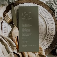 a table setting with place settings and napkins on it, including a menu card