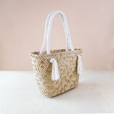 DESCRIPTION The classic handwoven straw bag with a twist. Featuring a rich herringbone texture with natural seagrass fiber and braided cord handles. A perfect beach accessory for your weekend getaways or a daily companion to carry your essentials. Handwoven by women weavers in the Philippines using traditional techniques. DETAILS • DIMENSIONS: Approx. L16" x W7.5" x H10.5" with 9" handle drop • MATERIAL: Seagrass, macrame cord • COLOR: Oat, natural CARE Spot clean only. Keep dry and store away f Elegant Handwoven Double Handle Beach Bag, Eco-friendly Straw Bag With Braided Handles For Shopping, Eco-friendly Beach Bag With Braided Handles For Shopping, Eco-friendly Rectangular Beach Bag With Braided Handles, Eco-friendly Woven Beach Bag With Double Handle, Herringbone Texture, Dishware Sets, Natural Care, Art Phone Cases