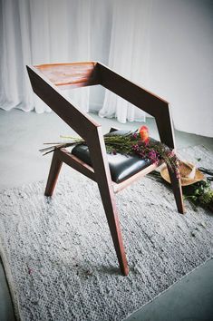 a chair that is sitting on the floor with flowers in it and some other things