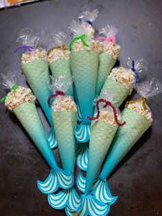 six cones filled with rice sitting on top of a black table next to plastic bags