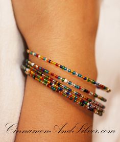 a woman's arm with multicolored beads on it and a white shirt