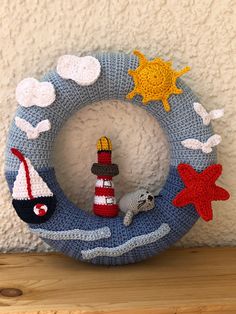 a crocheted wreath with a lighthouse, starfish and sea animal on it