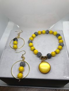 Beautiful Yellow And Gray Charm Bracelet With Matching Earrings Set Adjustable Costume Jewelry Sets With Round Shape, Nickel-free Bracelet, Yellow Bracelet Jewelry For Gift, Adjustable Yellow Dangle Jewelry, Yellow Round Beads For Jewelry Making, Adjustable Beaded Metal Jewelry Sets, Adjustable Yellow Jewelry Gift, Adjustable Yellow Jewelry As A Gift, Yellow Beaded Metal Jewelry