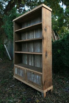 an old wooden bookcase sitting in the grass