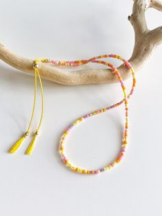 A colourful double wrap seed bead bracelet with pink, orange, yellow and purple seed beads on a yellow silk cord with a gold filled slider bead and accents. Inspired by the beautiful colours of a sunset every bracelet is unique as the beads are a random mixture of these colours. Delivered in our pretty gift box, so fantastic as a present for a friend or to yourself! Shipping Uk: 2-3 days - Royal Mail 48hr tracked International standard delivery: 6- 14 days (delays can occur especially in busy periods) Please be aware that standard shipping is UNTRACKED and does not need to be signed for but you do have the option to upgrade to tracked and signed shipping (someone must be available to sign for the parcel on delivery) International orders over £50 will automatically be upgraded to tracked an Adjustable Yellow Lariat Jewelry, Adjustable Pink Beaded Necklace For Friendship, Adjustable Yellow Lariat Necklace, Adjustable Orange Beaded Necklace With Tiny Beads, Adjustable Orange Beaded Necklaces With Tiny Beads, Colorful Adjustable Friendship Bracelets With Tiny Beads, Adjustable Colorful Friendship Bracelets With Tiny Beads, Colorful Adjustable Hand-strung Friendship Bracelets, Tiny Yellow Beads For Summer