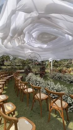 an outdoor dining area with tables and chairs covered in white fabric