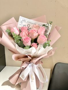 a bouquet of pink roses sitting on top of a table