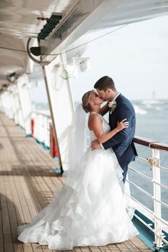 a bride and groom kissing on the deck of a cruise ship