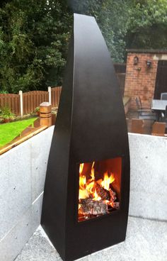 an outdoor fireplace with fire in it