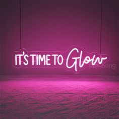 it's time to glow neon sign hanging from strings on the wall in front of a purple background