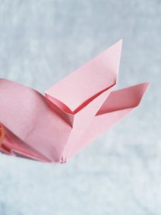 an origami bird made out of pink paper