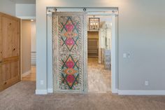 an open door leading into a room with carpeted flooring and wooden doors on both sides