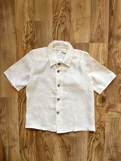 Cozy and vintage-looking linen boys' shirt. Made of natural and soft linen. This linen shirt is perfect for any occasion (e.g. formal event, birthday, family party, casual wear, etc.) and fits perfectly for baby boys, toddlers, and older boys. Handmade with care. 🌿 QUALITIES Has collar Has buttons for easy and comfortable change Not ironed (and no need to iron to have a relaxed look) Color in the picture - White 🌿 COMPOSITION This shirt is made from 100 % locally produced and OEKO-TEX® STANDAR Classic Cream Linen Top, Classic Cream Linen Shirt, Vintage Linen Shirt With Buttons, Vintage Linen Shirt With Button Closure, Vintage Linen Collared Shirt, Vintage Collared Linen Shirt, Boys Linen Shirt, Shirt With Buttons, Boys Shirt