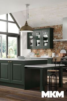 a kitchen with green cabinets and wooden floors