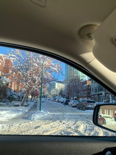 the view from inside a car looking at snow covered streets