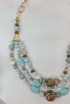 Our Blue Echo necklace is a three strand beauty, each strand an echo of the previous. It was carefully handcrafted with blue amazonite stone beads and contrasting gold vintage beads. The three strands are joined with an unusual and interesting triangular element. This necklace is completed with gold plated cable chain. As a gift for the beauty in your life or for yourself, this glamorous piece is perfect. A matching bracelet and earring set are available. Features: - Vintage Elements - Gold Plat Multi-strand Turquoise Gemstone Beads Necklace, Chain Ideas, Sundance Jewelry, Bracelet And Earring Set, Stolen Heart, Amazonite Necklace, Vintage Elements, Amazonite Stone, Purple Iris