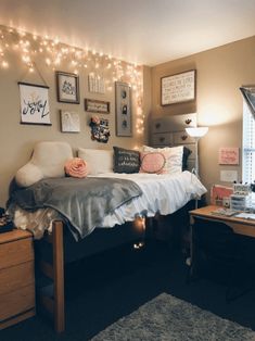 a bedroom decorated with string lights and pictures on the wall above the bed, along with other decorations