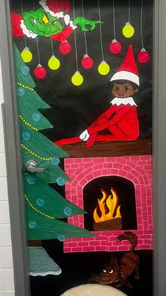 a door decorated with christmas decorations and an elf sitting in front of a fire place