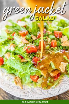 a salad with dressing being poured onto it and the words green jacket salad on top