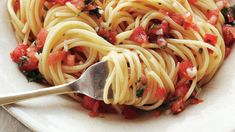 a white bowl filled with pasta and tomatoes