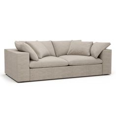 a beige couch with pillows on the back and side ends, in front of a white background