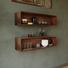 two wooden shelves with bottles and bowls on them in a room that has green walls